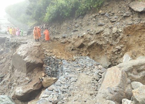 क्षतिग्रस्त मार्ग को ठीक करने में जुटे मजदूरों पर खराब मौसम की पड़ी मार